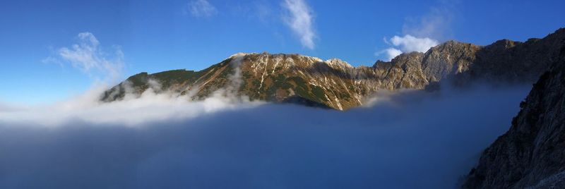 Panoramic view of mountain range against cloudy sky