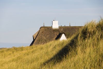 House on field against clear sky