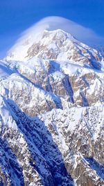 Scenic view of snowcapped mountains against blue sky