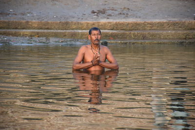 Portrait of shirtless man in lake