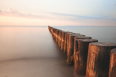 Pier over sea against sky during sunset