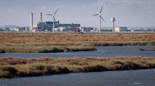 Windmills on field against sky