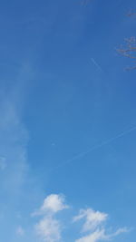 Low angle view of vapor trail against blue sky