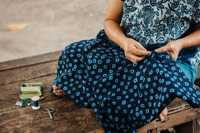 High angle view of woman sitting with toy on bench