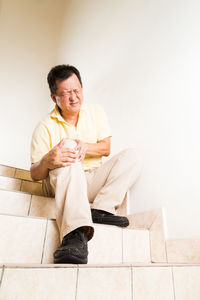 Man with knee pain sitting on steps
