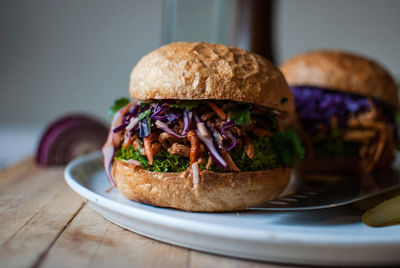 Close-up of burgers served in plate on wooden table