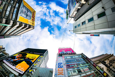 Low angle view of advertisement on buildings against sky