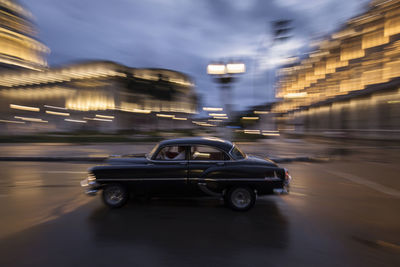 Car on illuminated city street at night