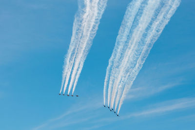 Low angle view of vapor trail against blue sky