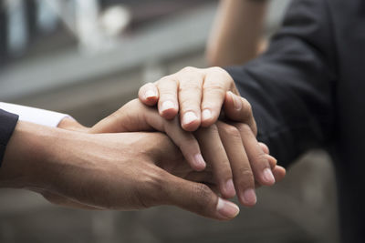 Cropped image of business colleagues stacking hands