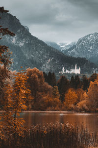 Scenic view of lake by mountains against sky during autumn