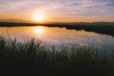 Scenic view of lake against sky during sunset