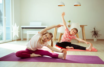 Siblings practicing yoga at home