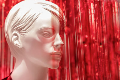 Close-up of mannequin against red decoration