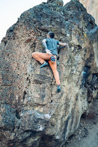 Male climber getting ready for a push to the boulder top in smith rock