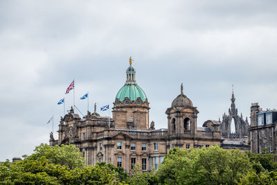 Buildings in city against cloudy sky