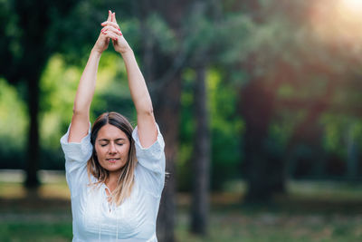Yoga woman, grounding in nature, tree pose, green background.