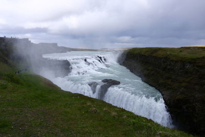 Scenic view of waterfall against sky