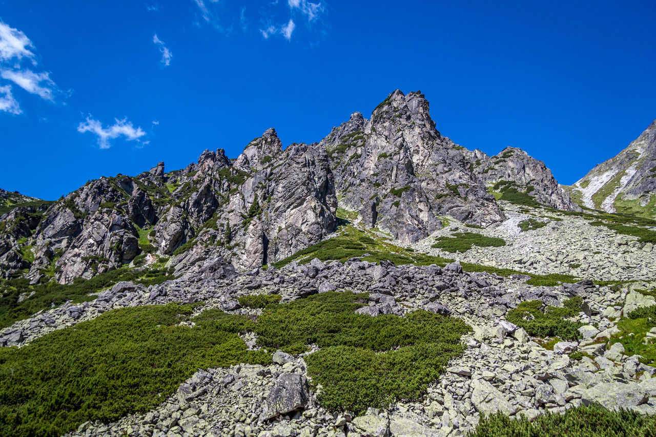 LOW ANGLE VIEW OF ROCKS AGAINST BLUE SKY