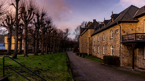 Footpath amidst buildings against sky