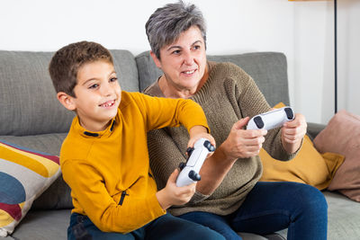 Little kid and his grandmother playing video games