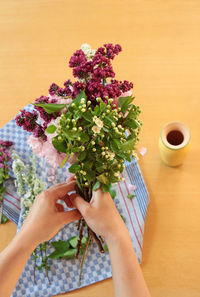 Midsection of person holding coffee cup on table