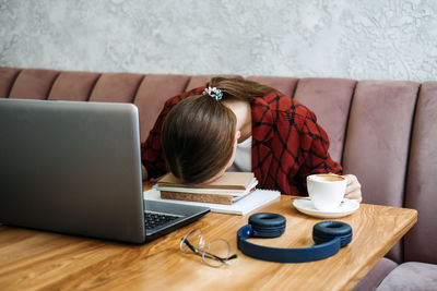 Student girl studying hard exam and sleeping on books in cafe. tired girl working