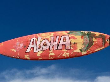 Low angle view of information sign against blue sky