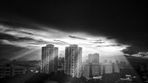 Buildings in city against cloudy sky