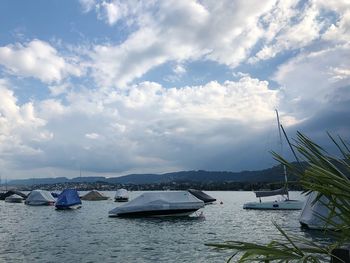 Boats moored in sea against sky