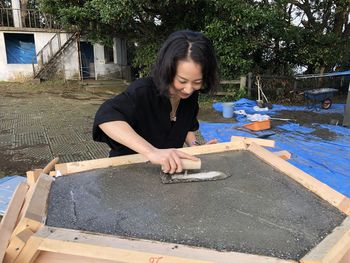 Full length of woman smiling while sitting in yard
