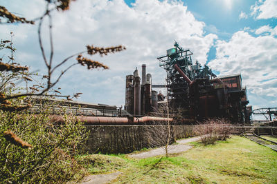 Abandoned factory on field against sky