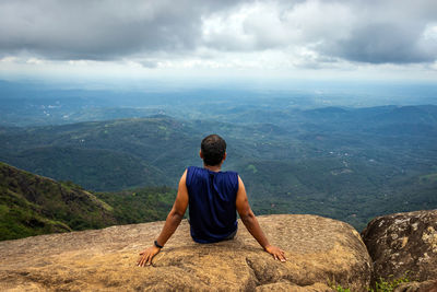 Rear view of man looking at view of mountains