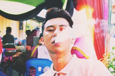 Close-up of young man exhaling smoke