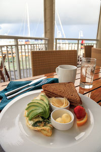 Egg white omelet with spinach, avocado slices and cheese along with wheat toast for breakfast