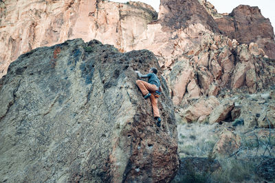 Male climber getting close to the top of the boulder in smith rock