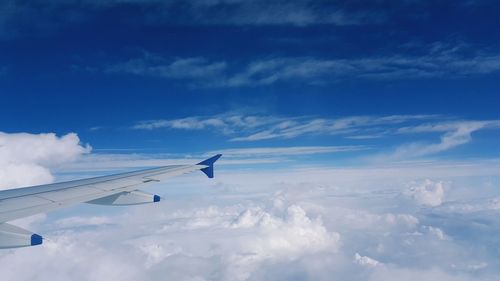 Cropped image of airplane wing flying against sky