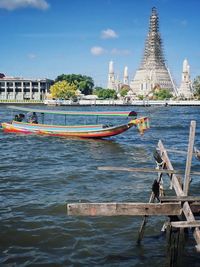 Boats sailing in river against sky