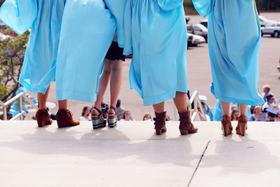 Low section of women in graduation gown on steps