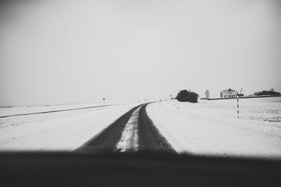 Road leading towards snow covered land