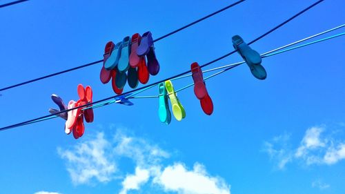 Low angle view of clothes hanging on clothesline against blue sky