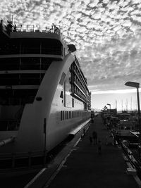 People walking on modern building against sky in city