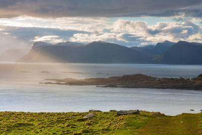 Scenic view of sea and mountains against sky