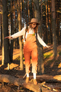 Woman botanist with backpack on ecological hiking trail in forest.