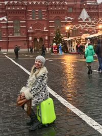 Woman walking on street in city during winter