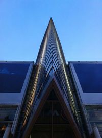 Low angle view of modern building against blue sky