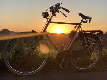 Bicycle parked on street during sunset