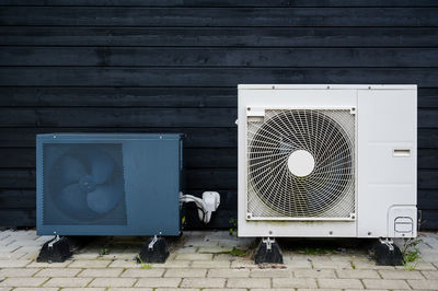 2 condensing units in front of black wall