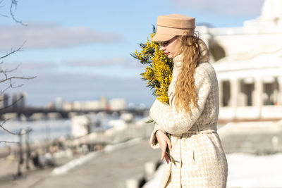 A  woman with a yellow acacia flowers. the concept of the spring - march 8, easter, women's day