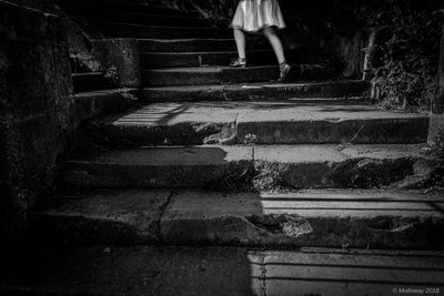 Low section of woman standing on staircase
